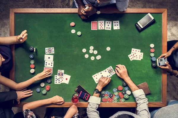 people playing poker at table in casino, top view