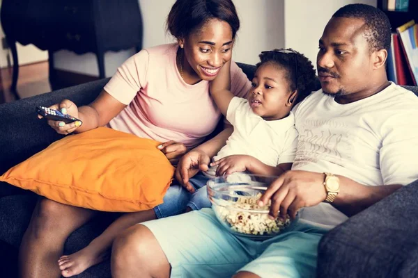 家で映画を見ながらポップコーンを食べるアフリカの家族 — ストック写真