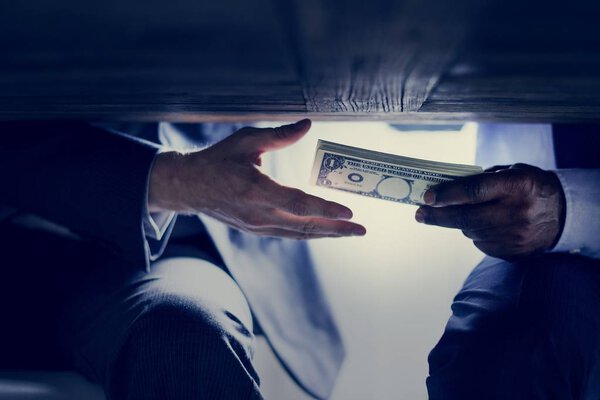 cropped image of male hands with money under table, corruption 