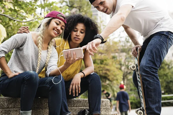 Amigos Adultos Jóvenes Usando Teléfono Inteligente Escuchando Música Aire Libre —  Fotos de Stock