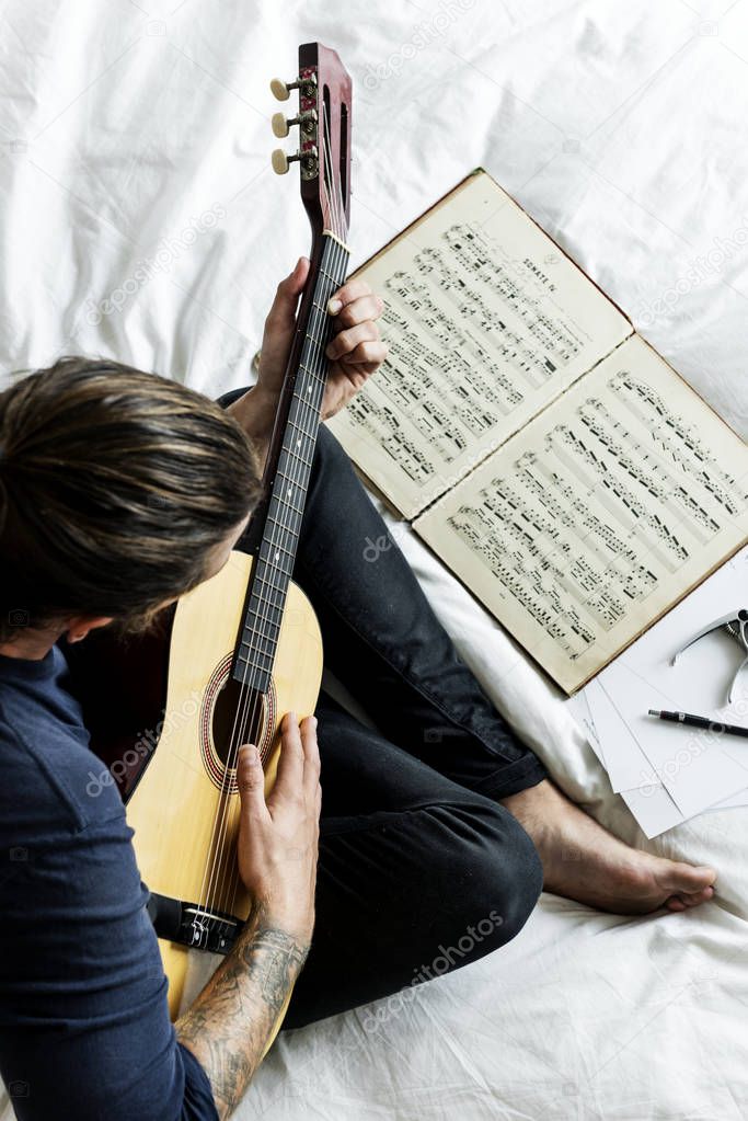 Man Practising notes with guitar