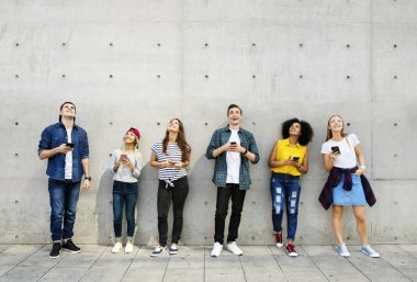 Grup genç yetişkin açık havada bakmak smartphones kullanarak