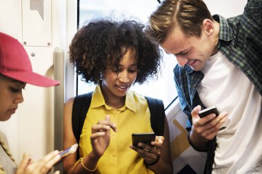 Akıllı telefonlar metroda kullanarak genç yetişkin arkadaş grubu