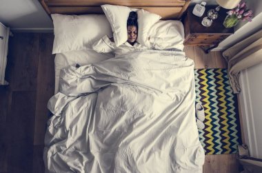 African American woman on bed insomnia and noise pollution concept clipart