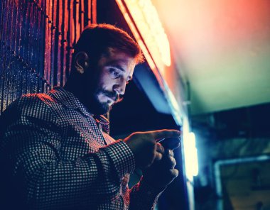 Karanlıkta uzun pozlama ışık ile cep telefonu kullanan bir adam closeup