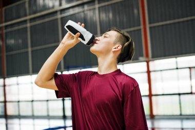 Young sporty man drinking sporty drink or water clipart