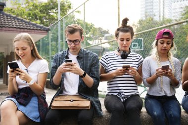 Genç Yetişkin arkadaşlar akıllı telefonlar birlikte kullanarak açık havada Gençlik Kültür kavramı