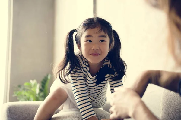 ソファの上の陽気な日本人の女の子 — ストック写真