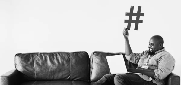 Fekete Férfi Pihentető Kanapén Tartja Laptop Val Kék Hashtag Jel — Stock Fotó