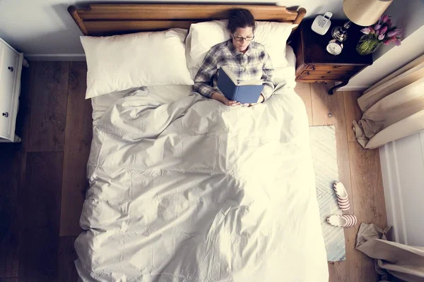 本を読んでのベッドの上の白人女性 — ストック写真