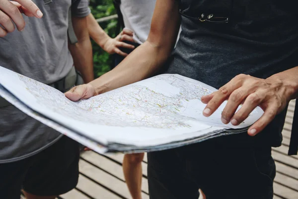 地図一緒に旅行とチームワークの概念を見ている友人のグループ — ストック写真