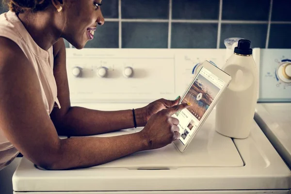 Mulher Africana Usando Tablet Digital Perto Máquina Lavar Roupa — Fotografia de Stock