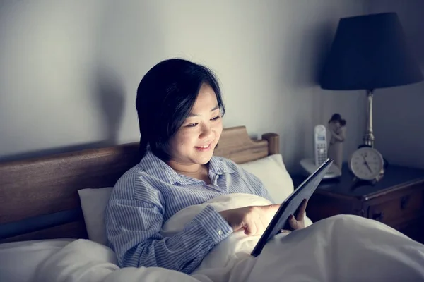 Uma Mulher Usando Comprimido Cama — Fotografia de Stock