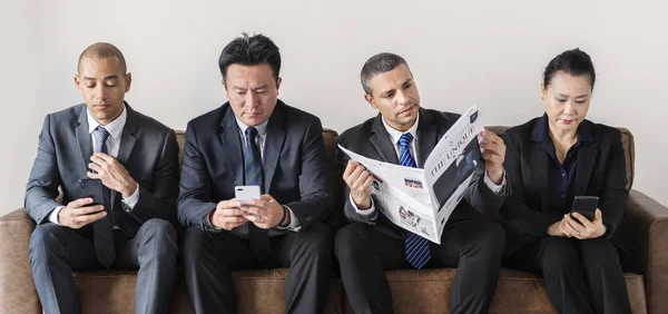 Negócios Navegando Telefones Celulares Lendo Jornal — Fotografia de Stock