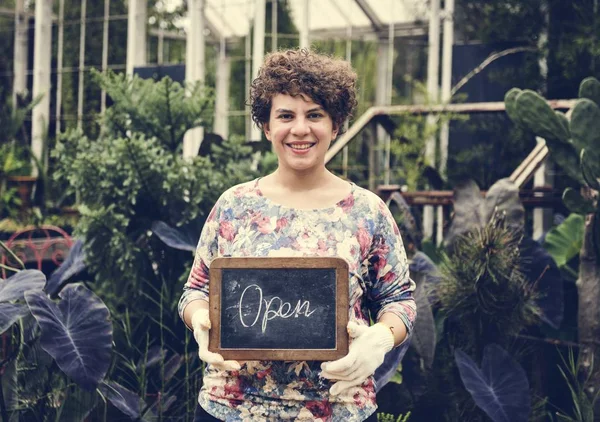 女性持株オープン サインを笑顔とカメラ目線 — ストック写真