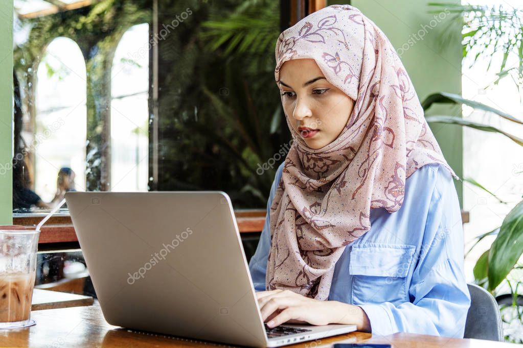 Islamic woman sitting and using laptop 