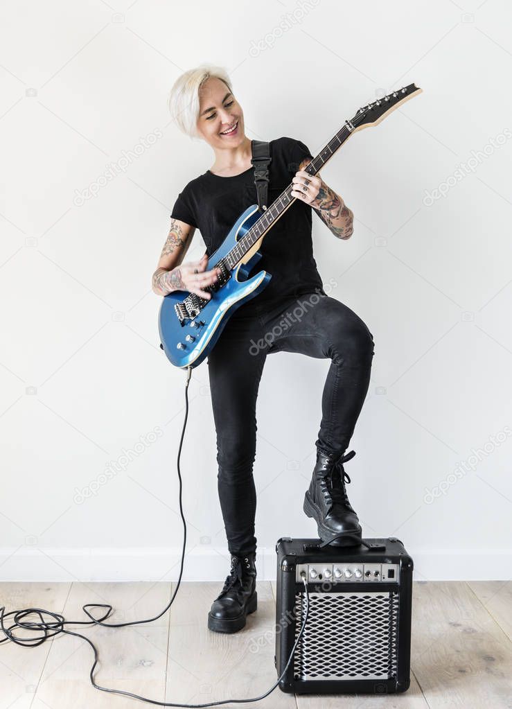 Tattooed woman playing electric guitar