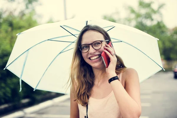 在雨伞下使用手机的女人 — 图库照片