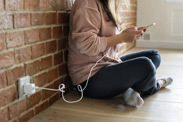 Ung Kvinna Med Smartphone Som Den Laddas — Stockfoto