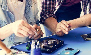 Bir grup insan eletronic tamir dükkanında çalışan