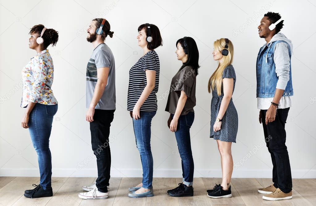 People standing in row line and listening music in headphones 