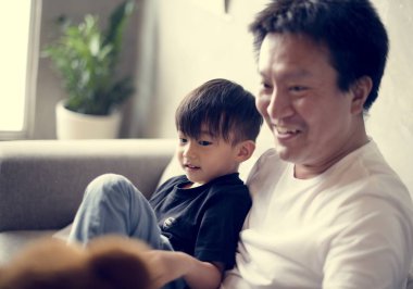 Japon baba ve oğul evde koltukta oturan 