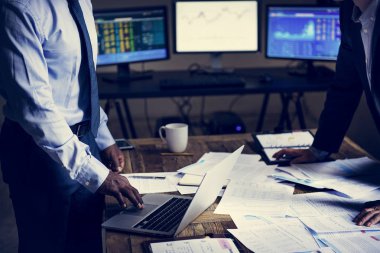 iş adamları bir toplantı birlikte dizüstü bilgisayar ve kağıtları tablo sahip. 