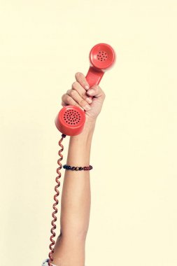 El beyaz izole kırmızı retro telefon tutarak