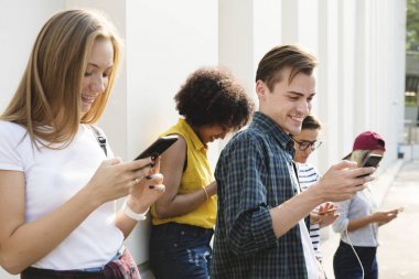 Arkadaşlar açık havada birlikte akıllı telefonlar kullanan ve soğutma