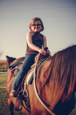 Genç kız at binme keyif alıyor