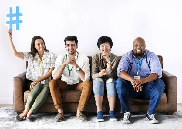 Diverse workers sitting together woman holding hashtag icon