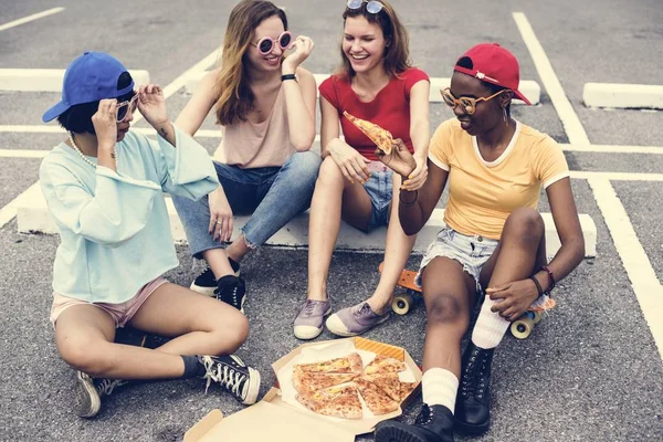 不同的妇女坐在地板上吃比萨饼一起 — 图库照片