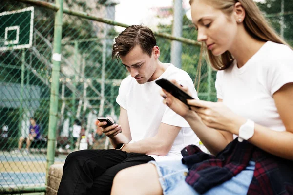 Pareja Joven Sin Expresión Parque Usando Teléfonos Inteligentes Sin Concepto — Foto de Stock