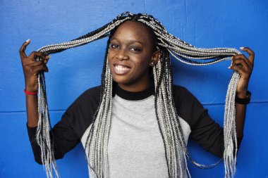 Kadın gülümsüyor, siyah portre Studio, dreadlocks ile mavi arka plan 