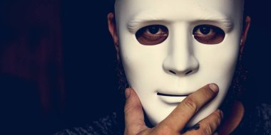 Beyaz maske holding ve yüz kapsayan bir adam