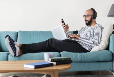 Kanepeye aygıt kullanan adam