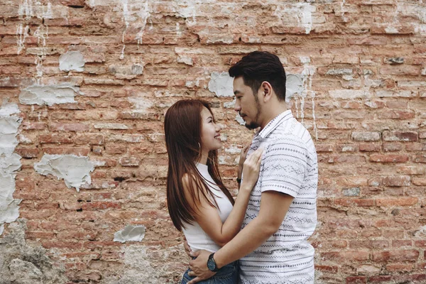 可爱的亚洲情侣在砖墙上 — 图库照片