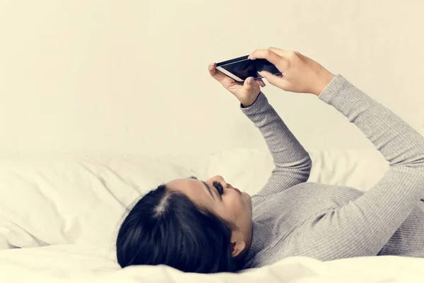 Азиатка Лежит Кровати Пользуется Мобильным Телефоном — стоковое фото