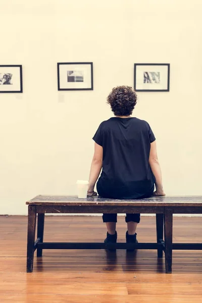 Mulher Sentada Banco Olhando Para Fotos Parede Galeria Arte Exposição — Fotografia de Stock