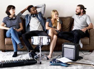 Divan, prova aletleri ile odada oturan müzik grubu 