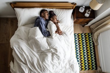 Güzel Afrikalı-Amerikalı çift yatakta snuggling