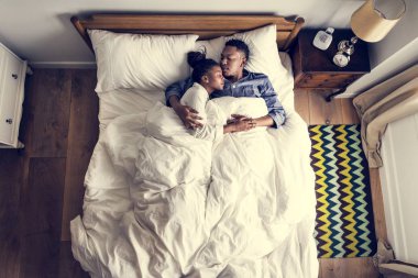 Güzel Afrikalı-Amerikalı çift yatakta snuggling
