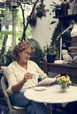 kafkas kadın bir kitap okurken rahatlatıcı kahve fincanı holding