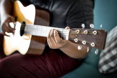 Akustik gitarla çalan adam