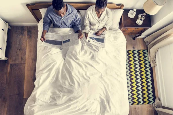 Afrikanisches Amerikanisches Paar Auf Dem Bett Beim Zeitungslesen — Stockfoto