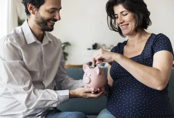 Family saving money in piggy bank