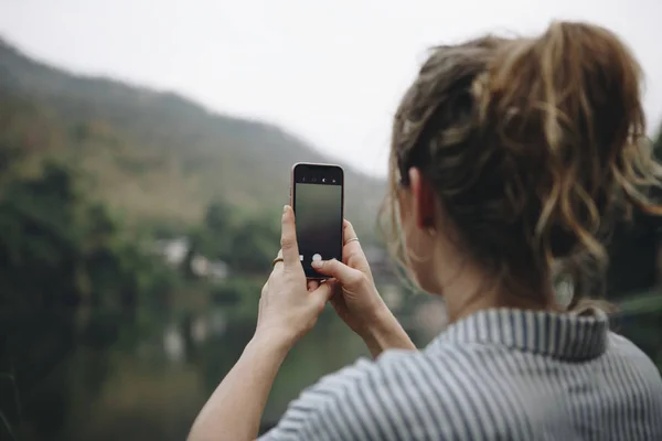 自然の旅行と観光のコンセプトの写真を取ることを彼女のスマート フォンを上げる女性の手のクローズ アップ — ストック写真