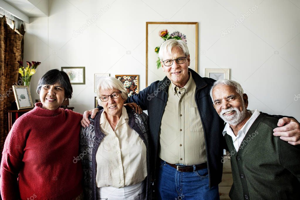 Group of senior friends arms around each other
