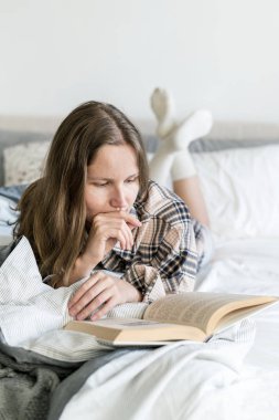konsantre kadın sabah yatakta kitap okumak