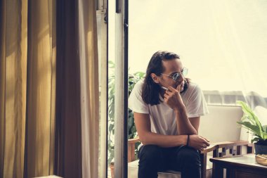 Oturan adam ve bir balkon sigara